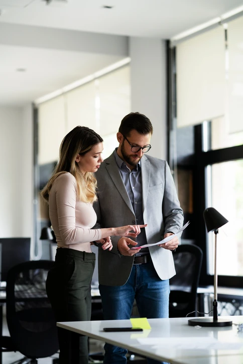 Réunion de travail en intérieur avec trois personnes collaborant autour d'une table