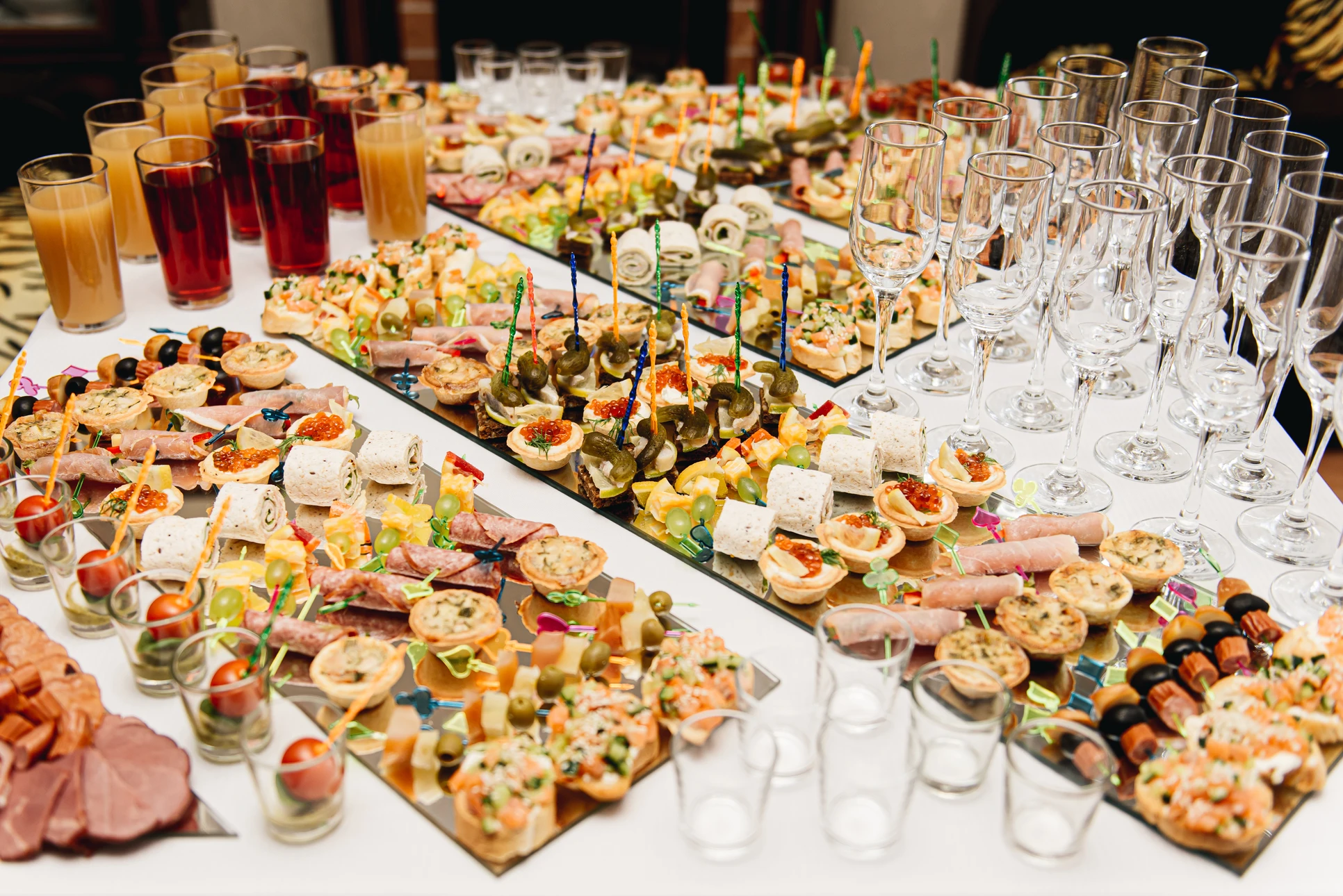 Photographie d'un food truck moderne et professionnel en action lors d'un événement extérieur (mariage, fête professionnelle ou rassemblement), montrant le personnel en tenue professionnelle préparant et servant des plats attractifs à des clients. Le food truck doit être bien visible, équipé, et l'ambiance générale doit transmettre la convivialité et le professionnalisme d'un service de street food événementiel haut de gamme.