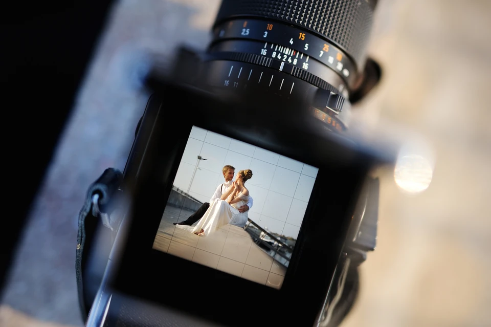 Couple de mariés en extérieur lors d'une séance photo romantique au coucher du soleil