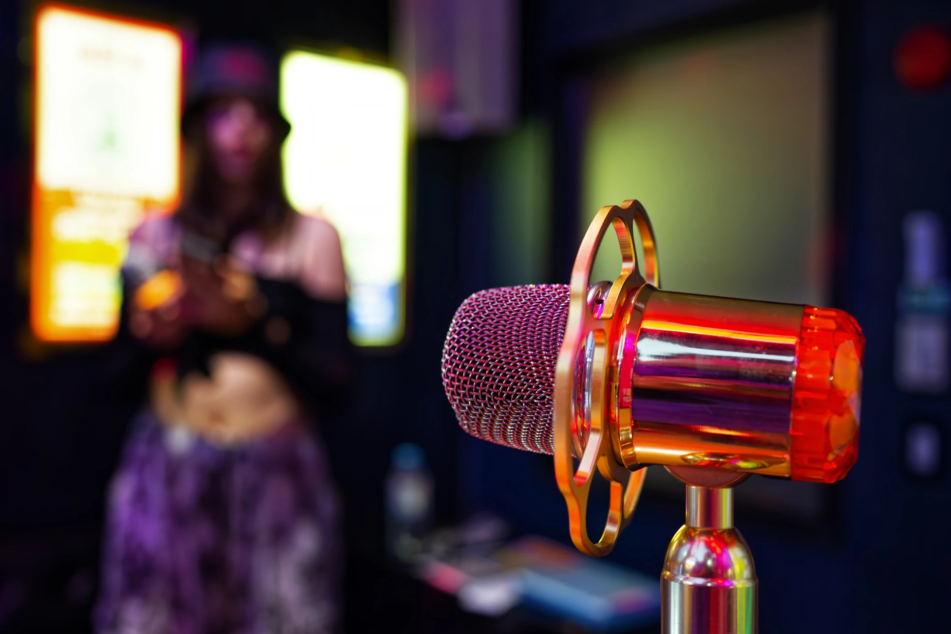 Scène de spectacle avec microphone vintage sur pied, éclairé par projecteur circulaire rouge sur rideau de velours