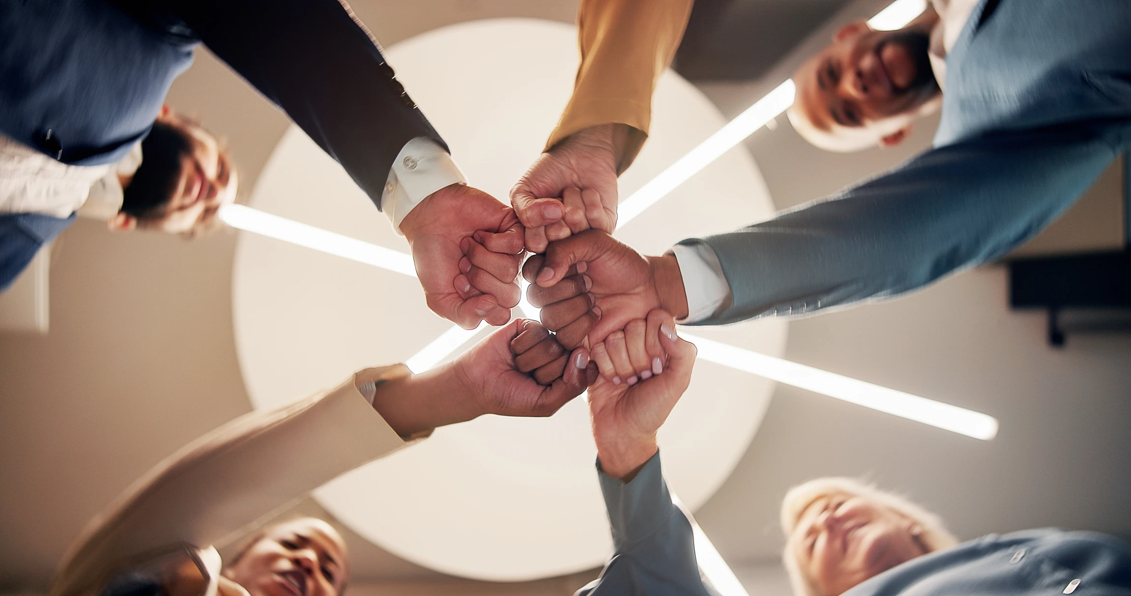 Scène extérieure en milieu urbain où quatre personnes en tenue de sport célèbrent ensemble par des high-fives après un entraînement collectif